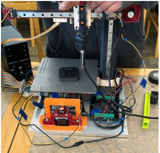 Heated toolhead positioned over a 3D-printed part on the bed